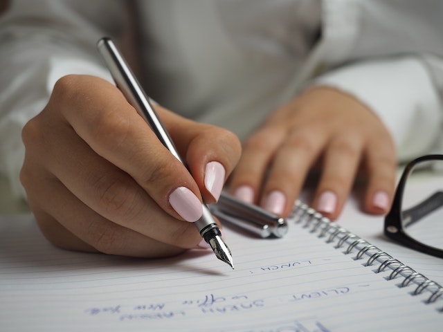 person holding a pend while signing a lease agreement